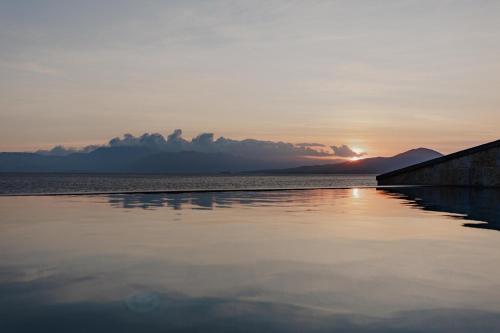 a sunset over a body of water with mountains in the background at Villa Kastos in Paleros