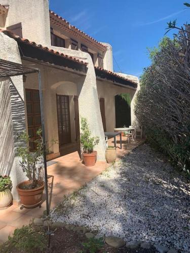 une maison avec des plantes en pot devant dans l'établissement Villa La Louette, 100m centre-village, piscine h-sol, proche mer, à Saint-Cyr-sur-Mer