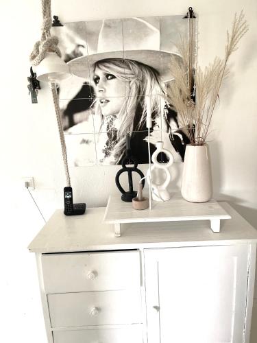 a white cabinet with a picture of a woman with an umbrella at Das Ruebezahl in Reit im Winkl