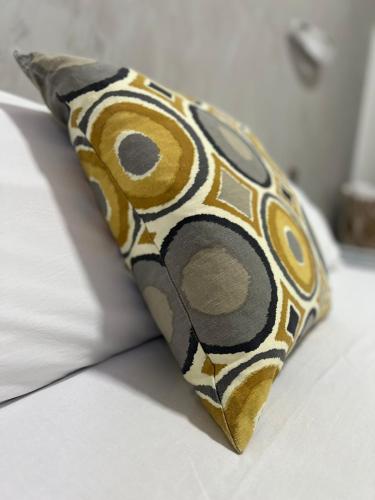 a yellow and black pillow on a bed at Le Tre Rose in Maratea