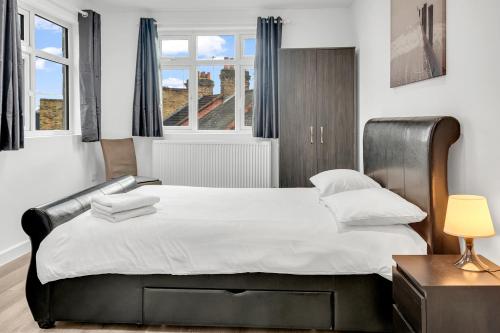 sypialnia z dużym łóżkiem i oknem w obiekcie Modern Apartment in South West Wandsworth w Londynie