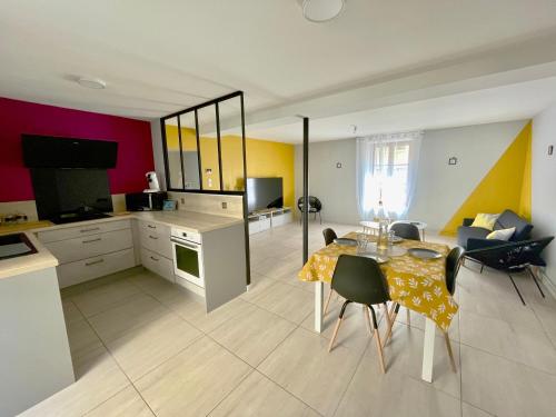 une cuisine et un salon avec une table et des chaises dans l'établissement Le petit jardinet de Tarare, à Tarare