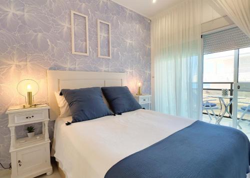 Un dormitorio con una cama azul y blanca y una ventana en Skol 438 Super One-bedroom Apartment with Sea Views, en Marbella