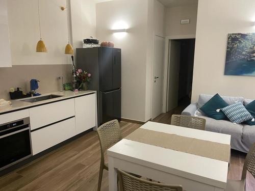托雷奧沃的住宿－A 34 passi dal mare，厨房和带黑色冰箱的客厅
