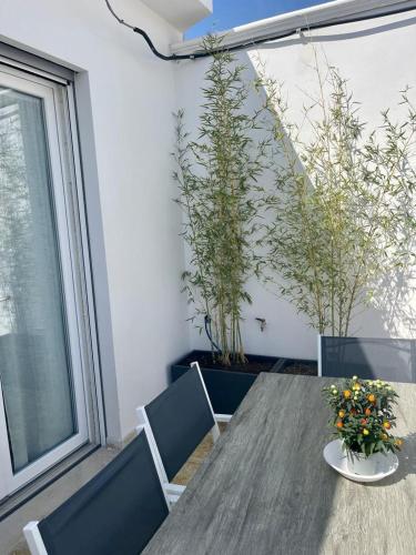 a wooden table with two chairs and flowers on it at A 34 passi dal mare in Torre Ovo