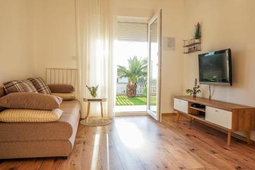 a living room with a couch and a flat screen tv at Apartment Komljenovic in Pula