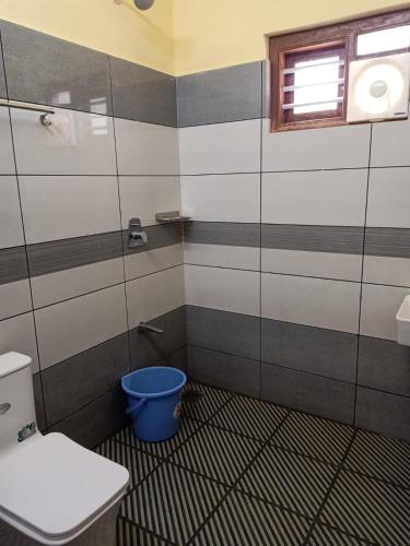 baño con aseo y cubo azul en OXYHUT RESORT, en Wayanad