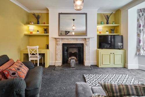 a living room with a fireplace and a tv at Host & Stay - The Courtyard at No.47 in Scarborough
