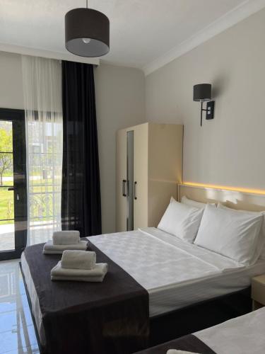 a bedroom with a bed with two towels on it at Otel Beyaz İnci in Palamutbuku