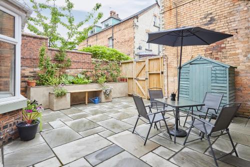 a patio with a table and chairs and an umbrella at Host & Stay - The Courtyard at No.47 in Scarborough