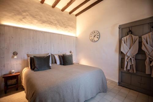 1 dormitorio con 1 cama y reloj en la pared en Agroturismo Son Boronat, en Calviá