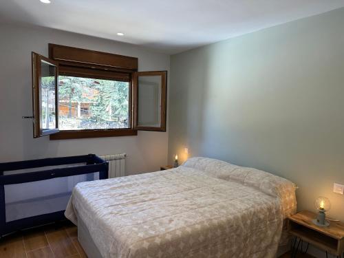 um quarto com uma cama e uma janela em El secreto del pinar em El Hoyo de Pinares