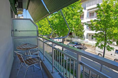 a balcony with two chairs and a view of a street at OLGA STUDIOS in Olympiaki Akti