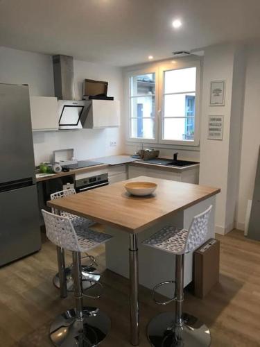 a kitchen with a wooden table and two chairs at Bel appartement 6p Tours Centre in Tours
