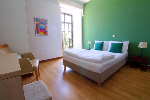 a bedroom with a large bed with a green wall at WOT Sintra Sarrazola in Sintra