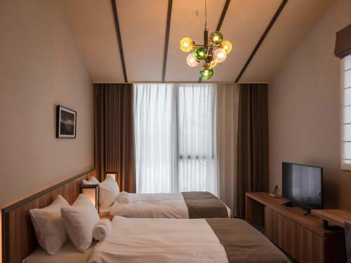 a hotel room with two beds and a chandelier at Panorama Niseko in Kutchan