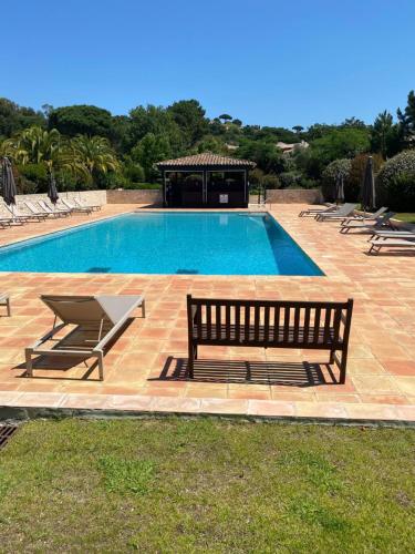 - une piscine avec deux bancs et une table dans l'établissement Maison domaine Golf Country Club de St-Tropez, à Saint-Tropez