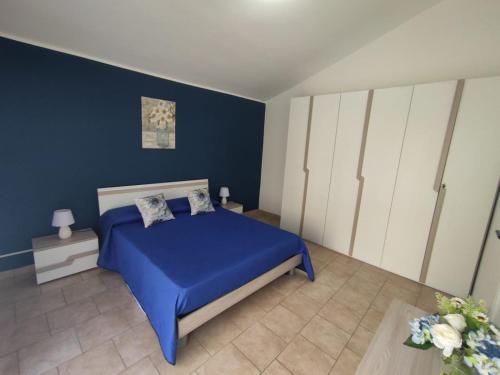 a blue bedroom with a bed and white cabinets at Ranieli Apartments in Drapia
