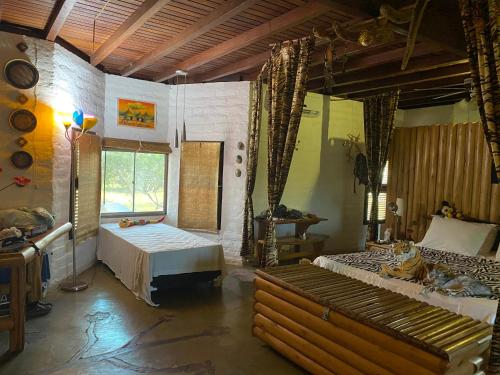 a large room with two beds and a window at Casa e bangalôs - Refugio Lodge- Sto Inacio - 3km de Atins in Atins