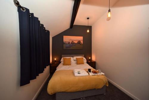 a bedroom with a large bed with yellow sheets at Chester Road Serviced Apartments in Macclesfield