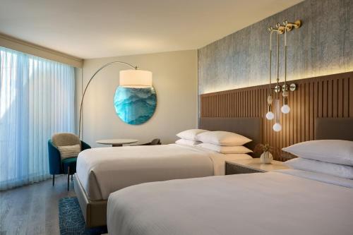 a hotel room with two beds and a blue vase on the wall at VEA Newport Beach, a Marriott Resort & Spa in Newport Beach