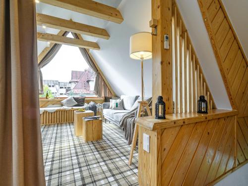 a living room with a staircase and a large window at VisitZakopane - Willa Bajka Apartments in Zakopane