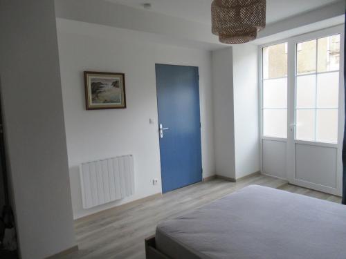 a bedroom with a blue door and a window at Le gîte des fresques in Saint-Savin-sur-Gartempe