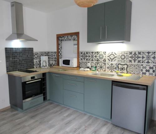 a kitchen with blue cabinets and a counter top at Le gîte des fresques in Saint-Savin-sur-Gartempe
