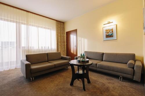 a living room with two couches and a table at Arka Medical Spa in Kołobrzeg