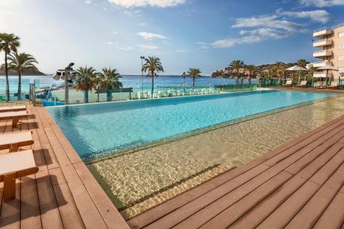 a swimming pool with the ocean in the background at INNSiDE by Meliá Wave Calviá in Magaluf