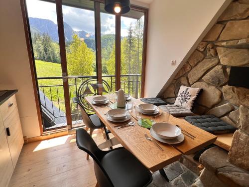a dining room with a table and chairs and a large window at Villa Tatrydom in Zakopane