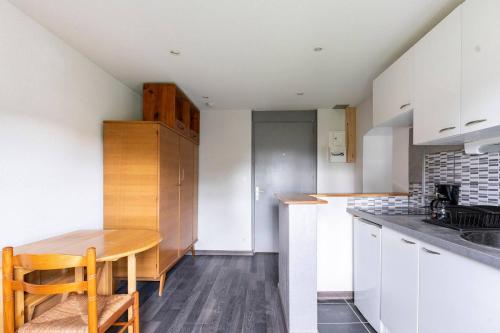 a kitchen with white cabinets and a wooden table at Détente et sport 3 - Chartreuse et Lacs - Appartement entier in Saint-Béron