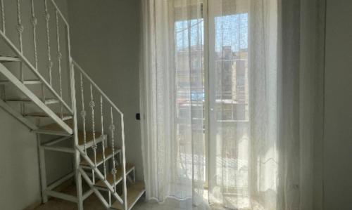 ナポリにあるCasa Antonellaの白いカーテン付きの大きな窓の横の階段
