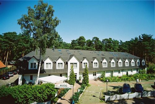 een groot wit gebouw met zonnepanelen op het dak bij Hotel Kaliebe in Trassenheide