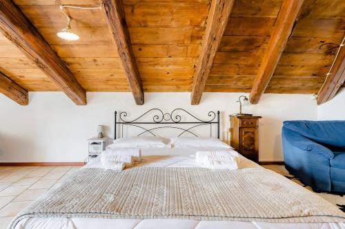 a bedroom with a large bed and a blue chair at Mansarda romantica "Il nido delle rondini" in Conversano