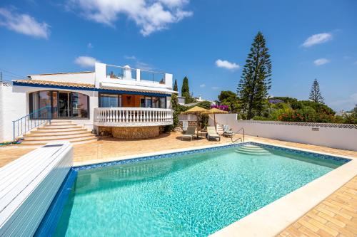 a villa with a swimming pool in front of a house at Casa Azul in Luz
