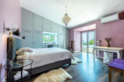 a bedroom with pink walls and a bed and a table at Casa Azul in Luz