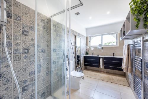a bathroom with a toilet and a glass shower at Casa Azul in Luz