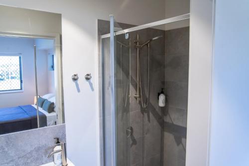 a bathroom with a shower with a glass door at Mackay Adventure Lodge in Mackay