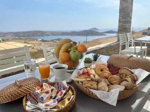 una mesa con dos cestas de pan y fruta en Serifos Blue en Rámos