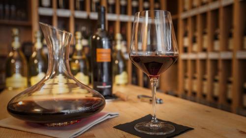 a glass of wine sitting next to a bottle of wine at Parkhotel Delta, Wellbeing Resort in Ascona