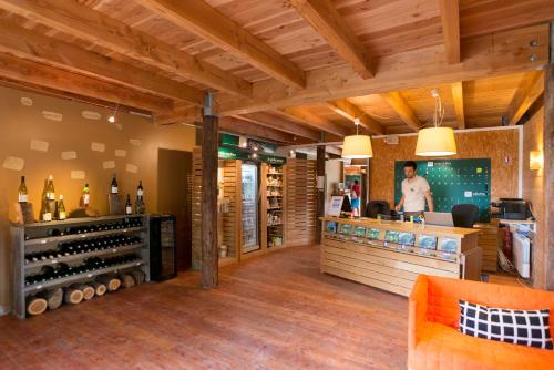 a wine bar with a man standing behind a counter at Village Huttopia Senonches - Perche in Senonches