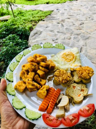 a plate of food with meat and vegetables on it at Trang an green river homestay in Ninh Binh