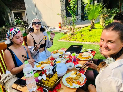 a group of women sitting at a table eating food at Trang an green river homestay in Ninh Binh