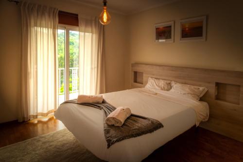 1 dormitorio con 1 cama blanca grande y toallas. en Bella Casa, en Vieira do Minho