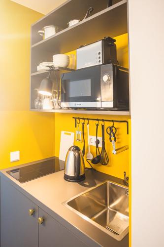 a kitchen with a sink and a microwave at Nena Apartments Bochum City in Bochum