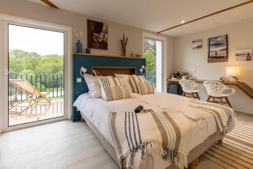 a bedroom with a large bed and a balcony at Domaine Baruteau in Soustons