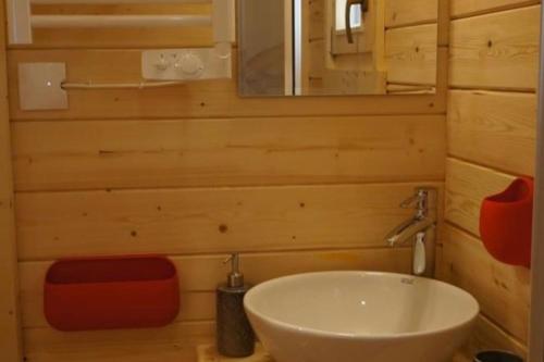 a bathroom with a sink and a mirror at Le Pont Rouge Roulotte in Sylvéréal