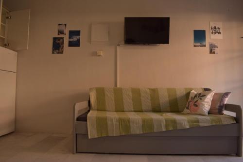 a living room with a couch and a tv on the wall at Iris House in Ierissos