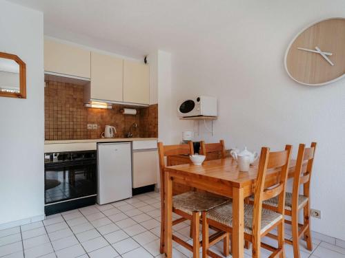 une cuisine avec une table et des chaises en bois dans l'établissement Appartement cosy à Carnac, 200m de la plage, terrasse, parking, TV, animaux acceptés, pour 4 personnes - FR-1-477-96, à Carnac